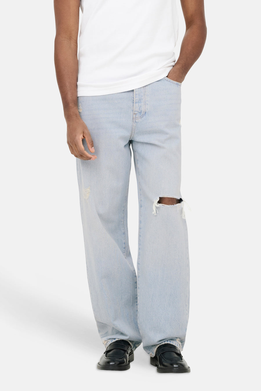 Jean large bleu clair ONLY & SONS avec déchirure au genou, porté par un homme.
