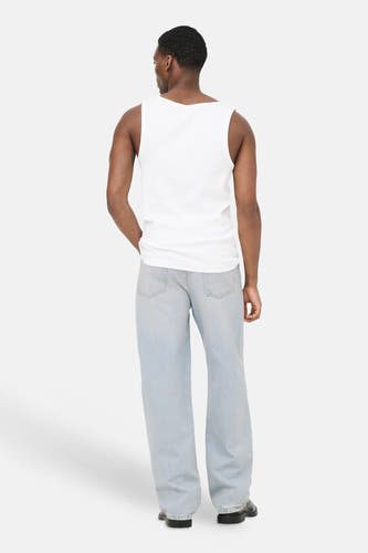 Jean large en denim bleu clair ONLY & SONS®, porté de dos par un homme, avec poches arrière visibles et ourlets effilochés.
