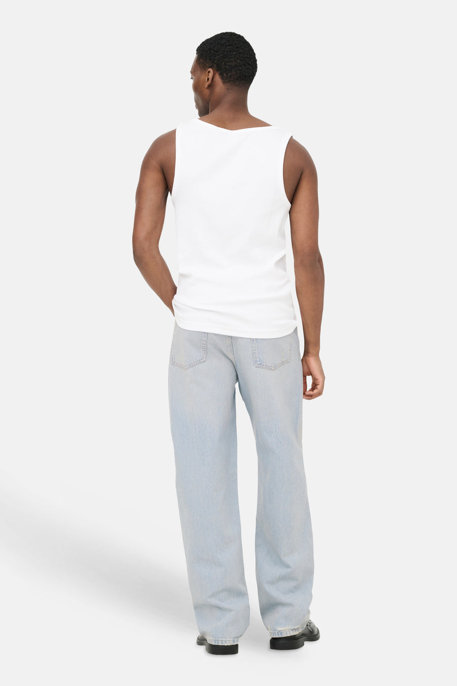 Jean large en denim bleu clair ONLY & SONS®, porté de dos par un homme, avec poches arrière visibles et ourlets effilochés.