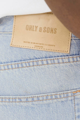 Jean ample bleu clair en denim de ONLY & SONS, avec une étiquette en cuir marron et des surpiqûres orange à l'arrière.