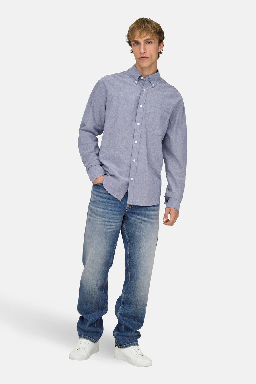 Jeans coupe droite bleu moyen en denim de ONLY & SONS, combiné avec une chemise bleue à manches longues et des baskets blanches.