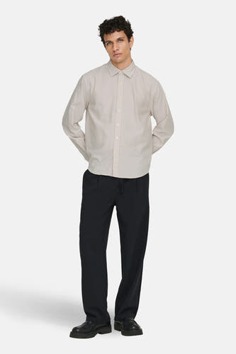 Chemise beige à manches longues de ONLY & SONS®, avec des rayures verticales et portée avec un pantalon noir et des chaussures.