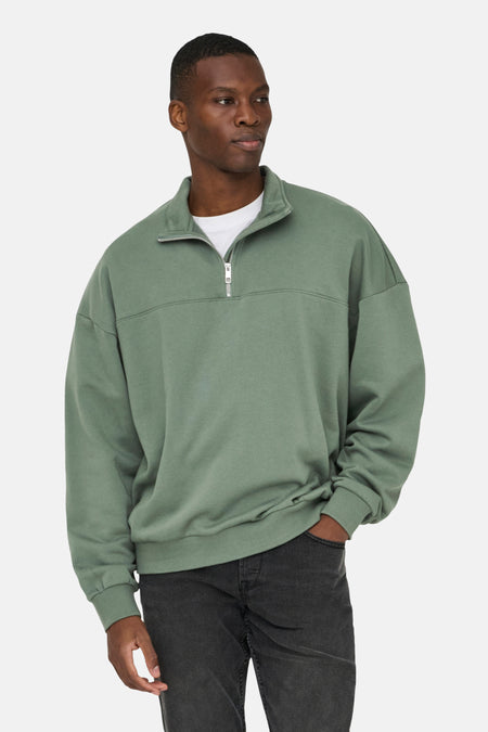 Man met groene trui en donkere jeans.