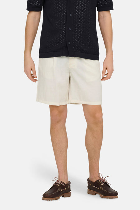 Short écru ONLY & SONS, combiné avec une chemise bleu marine ouverte et des chaussures marron.