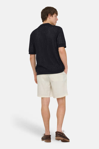 Short écru de ONLY & SONS, combiné avec un polo noir à motif et des chaussures bateau marron.