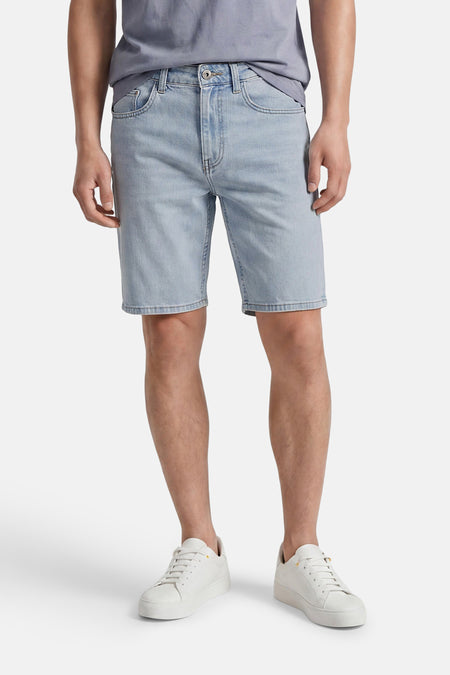 Lichtblauwe denim short van ONLY & SONS®, gedragen door een man met een grijs T-shirt en witte sneakers.