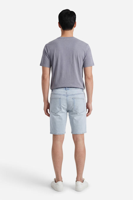 Lichtblauwe denim short van ONLY & SONS, van achteren gezien, met achterzakken, gedragen met een grijs T-shirt en witte sneakers.