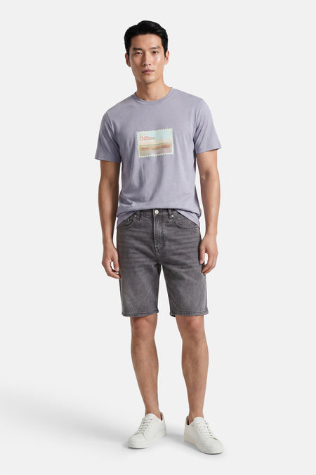 Short en jean gris clair de ONLY & SONS® avec un aspect délavé, porté avec un t-shirt violet et des baskets blanches.