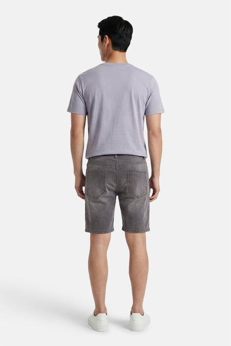 Lichtgrijze denim short van ONLY & SONS® met vervaagde look, gedragen door man in grijs T-shirt en witte sneakers, rugzicht.