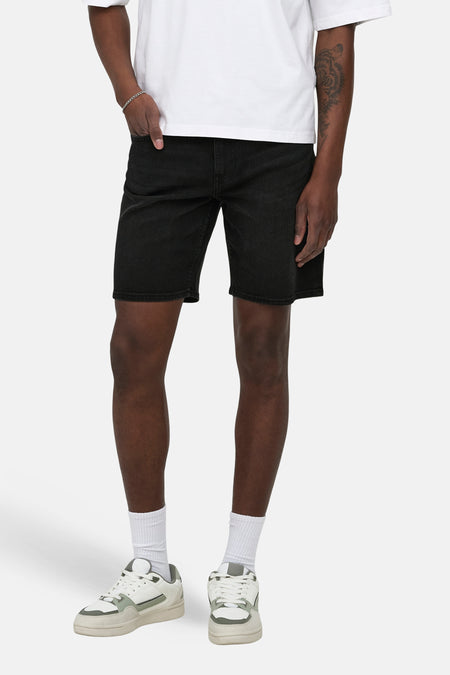 Short en jean noir en denim de ONLY & SONS®, porté avec un t-shirt blanc et des chaussettes blanches avec des baskets.