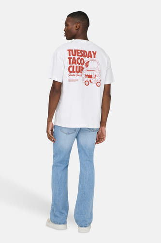 T-shirt blanc à manches courtes ONLY & SONS®, avec imprimé rouge au dos, combiné avec un jean bleu et des baskets blanches.