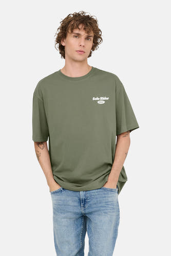 T-shirt vert avec manches courtes de ONLY & SONS, avec une petite impression blanche et porté avec un jean bleu.