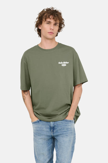 T-shirt vert avec manches courtes de ONLY & SONS, avec une petite impression blanche et porté avec un jean bleu.