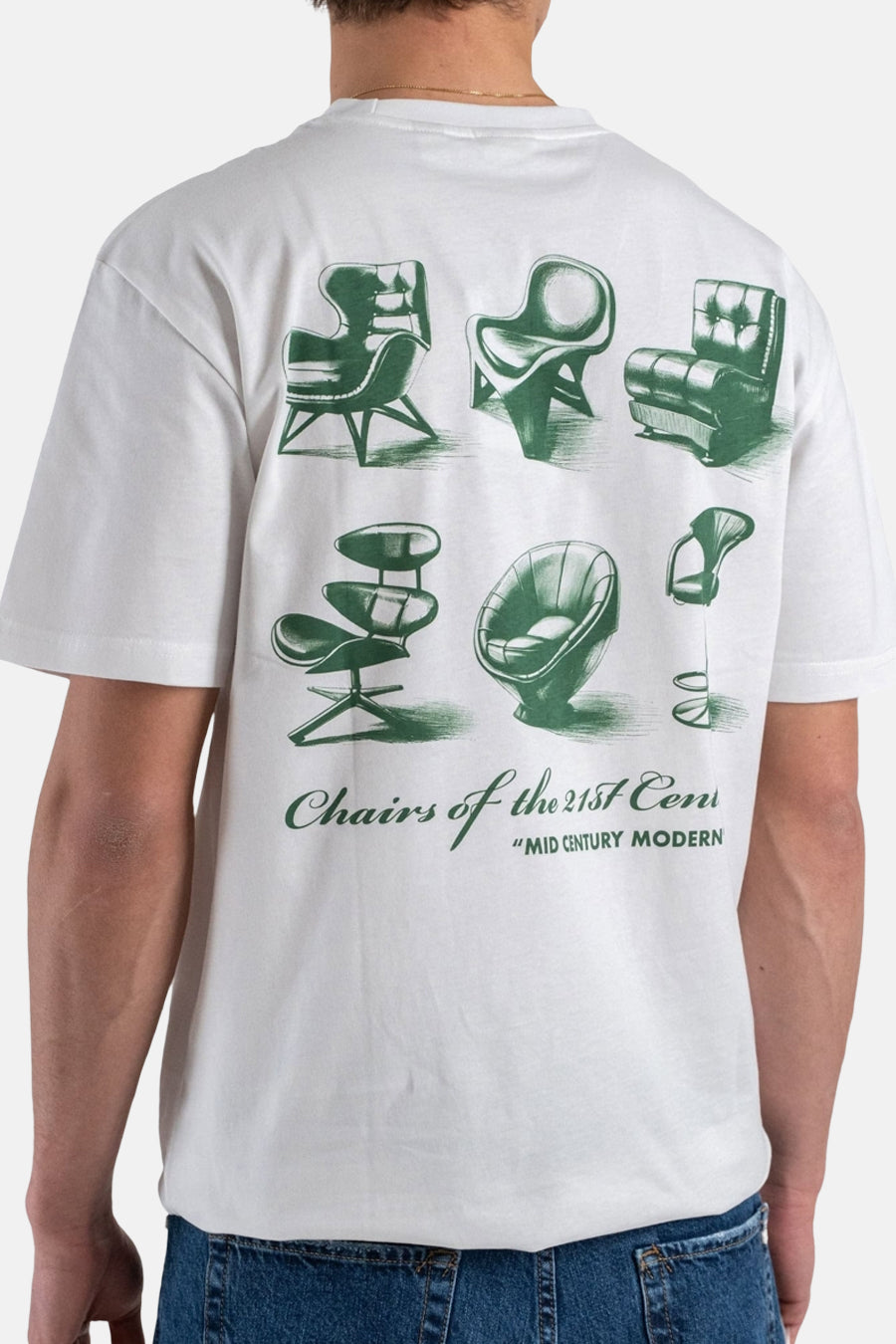 T-shirt blanc à manches courtes ONLY & SONS, avec motifs de chaises vertes et texte dans le dos, porté avec un jean.
