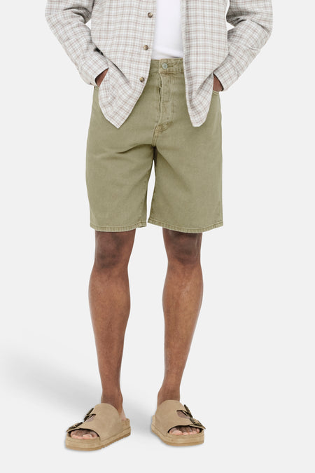 Short en jean beige de ONLY & SONS, porté par un homme avec une chemise à carreaux ouverte et des sandales.