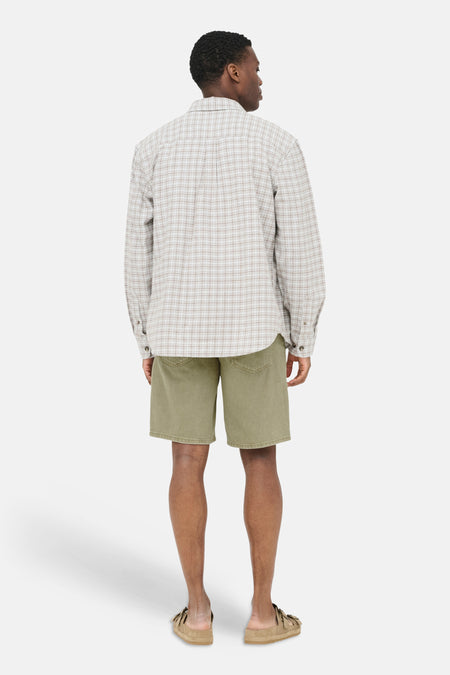 Short en jean beige de ONLY & SONS®, vu de dos sur un homme avec une chemise à carreaux et des sandales.