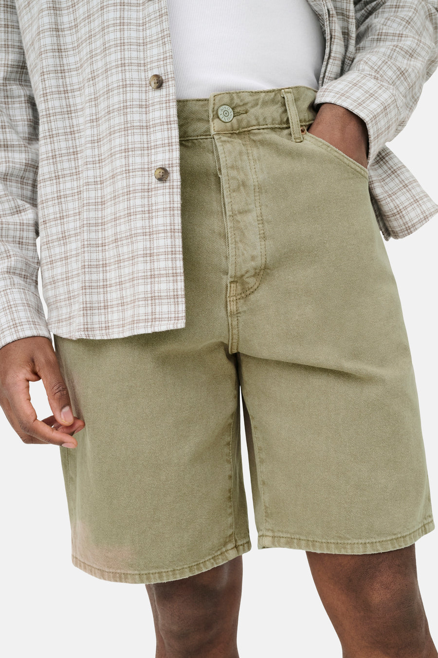 Short en jean de couleur beige de ONLY & SONS avec bouton métallique et texture légère, porté avec une chemise à carreaux et un t-shirt blanc.