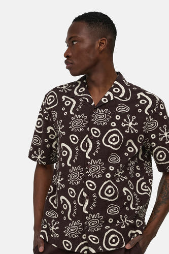 Chemise marron à manches courtes ONLY & SONS® avec motif abstrait blanc et col à revers, portée par un homme de profil.