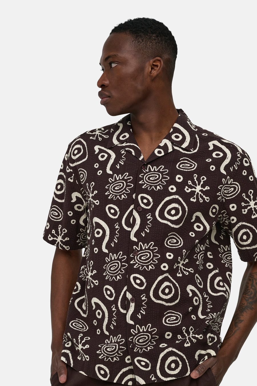 Chemise marron à manches courtes ONLY & SONS® avec motif abstrait blanc et col à revers, portée par un homme de profil.