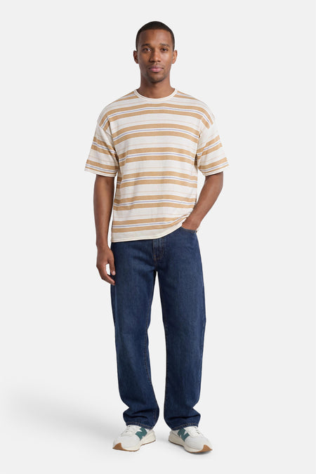 T-shirt rayé multicolore ONLY & SONS® coupe décontractée, porté par un homme avec un jean et des baskets.