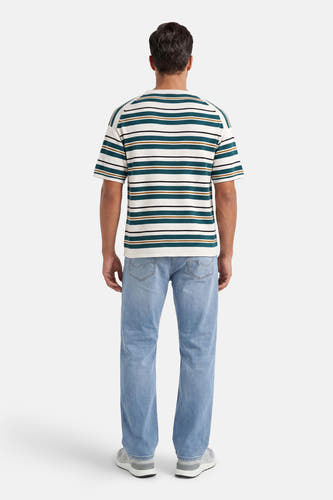 Crème, groen, bruin en zwart gestreepte T-shirt van ONLY & SONS®, achterkant op een man met lichtblauwe spijkerbroek en grijze sneakers.