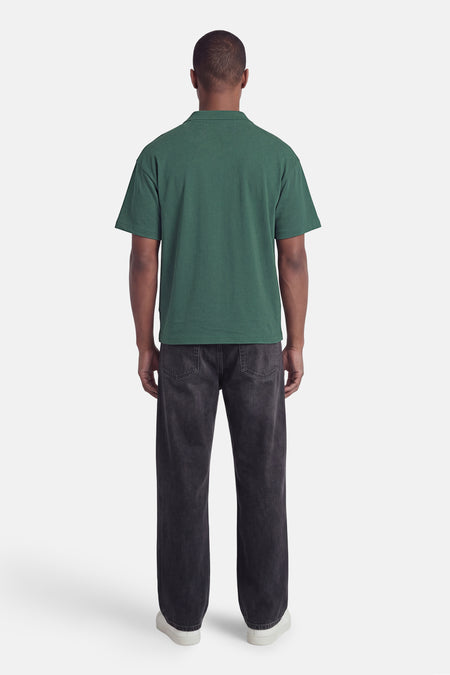 Polo verte ONLY & SONS® de couleur verte avec col, manches courtes et tissu texturé, dos, portée avec un jean foncé et des baskets blanches.