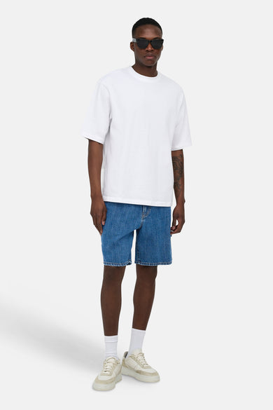 Mid-blauwe denim short van ONLY & SONS, gedragen door een man met een wit T-shirt en beige sneakers.