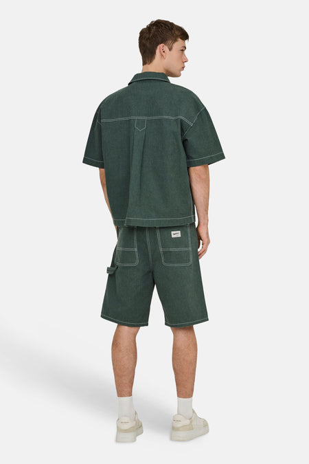 Chemise verte à manches courtes ONLY & SONS® avec surpiqûres contrastées blanches et coupe ample, vue de dos, portée avec un short assorti.