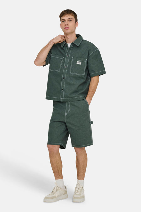 Groene short van ONLY & SONS met witte contraststiksels en een gereedschapslus, gedragen in een bijpassende set.