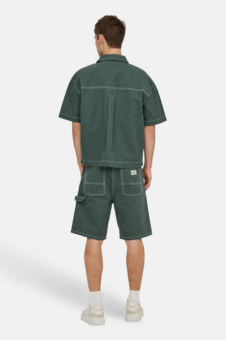 Shorts verts ONLY & SONS® avec surpiqûres contrastées blanches et poches utilitaires, portés avec une chemise assortie.
