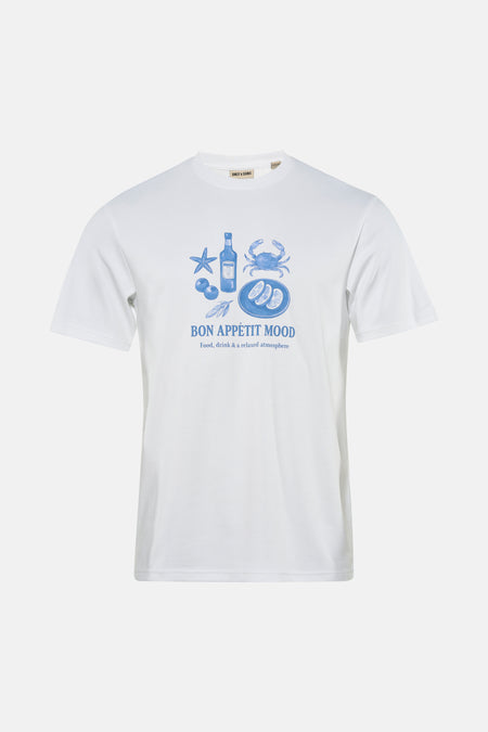 T-shirt blanc à manches courtes ONLY & SONS® avec imprimés bleus, porté avec un jean déchiré et des baskets.