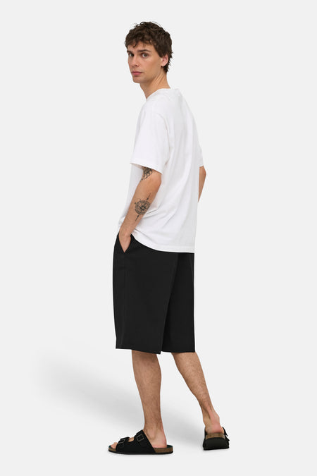 Zwarte korte broek van ONLY & SONS®, zijprofiel, gestreept model, casual look met wit T-shirt en zwarte slippers