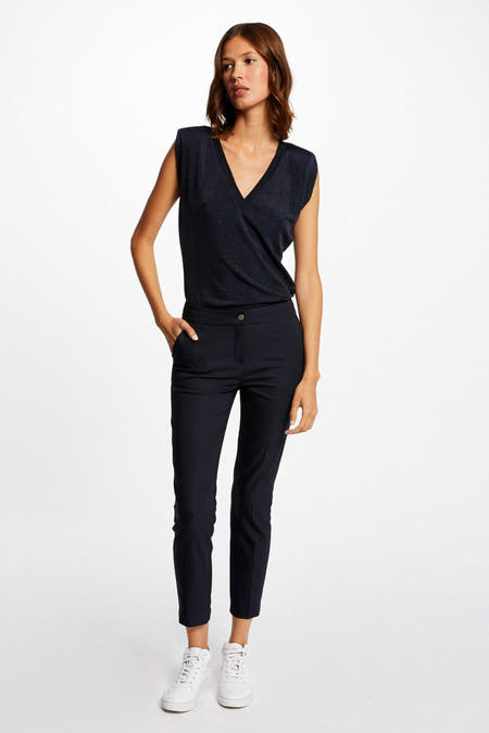 Pantalon de costume noir de Morgan De Toi, vu de l'arrière, associé à des sneakers blanches et un haut sans manches.