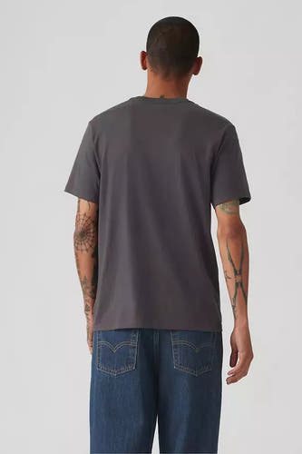 T-shirt gris à manches courtes de Levi's, avec des tatouages sur les bras, associé à un jean bleu, vue arrière.