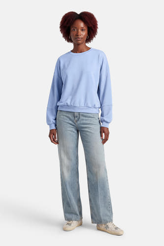 Pull bleu de Terra di Siena, à manches longues et combiné avec un jean et des baskets.