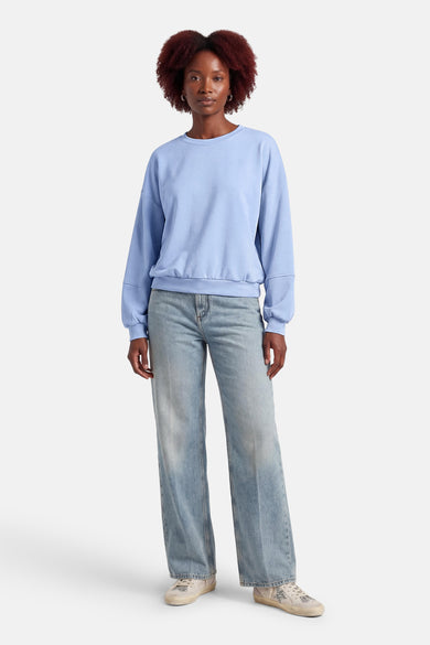 Pull bleu de Terra di Siena, à manches longues et combiné avec un jean et des baskets.