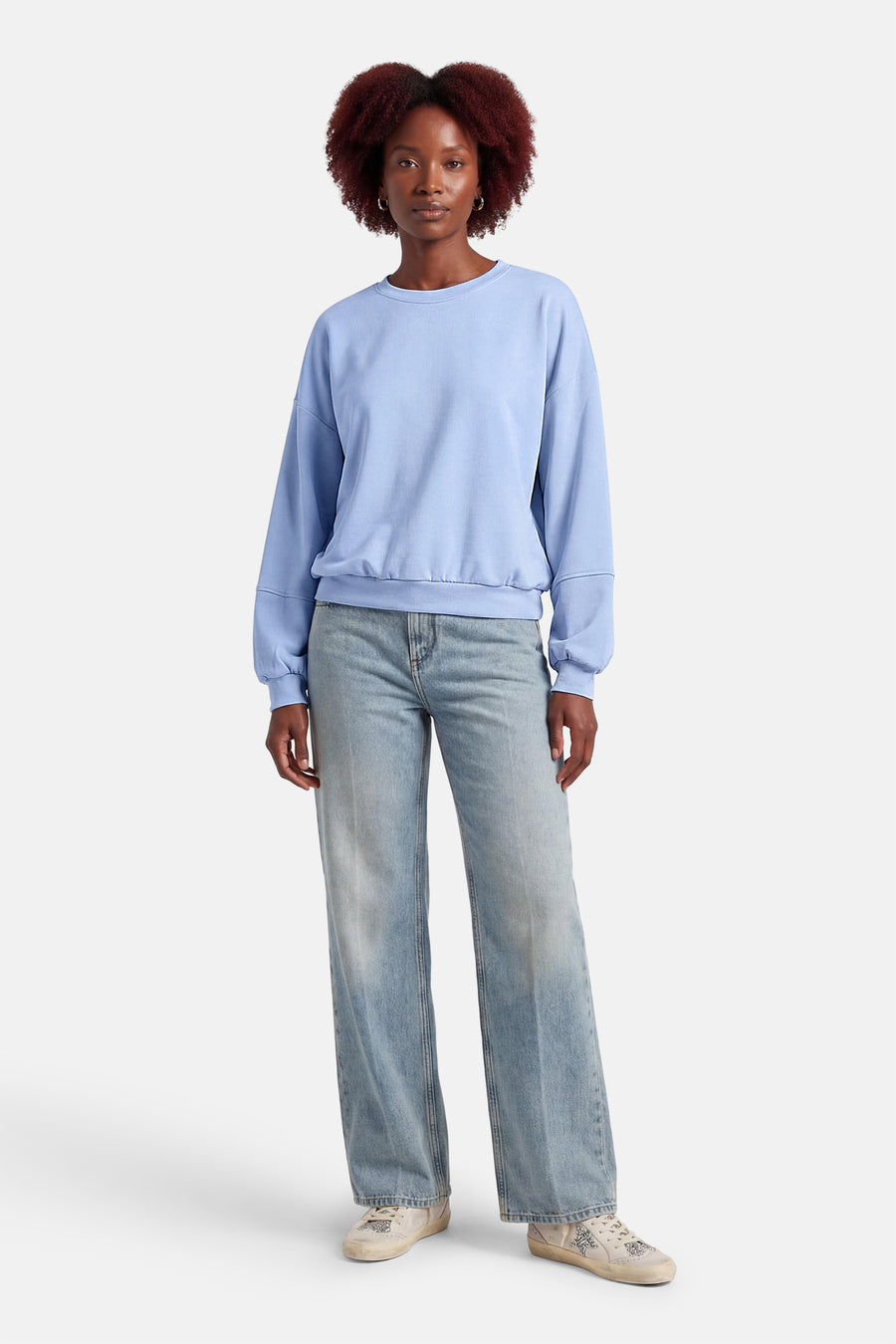Pull bleu de Terra di Siena, à manches longues et combiné avec un jean et des baskets.