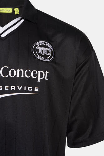 T-shirt noir à manches courtes de THEJOGGCONCEPT, avec logo sur la poitrine et rayures verticales.
