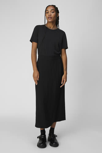 T-shirt noir d'OBJECT, associé à une longue jupe noire et des chaussures Mary Jane noires avec des chaussettes.