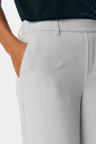 Pantalon gris d'OBJECT, avec une main dans la poche et un design simple.
