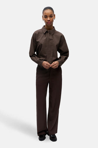 Pantalon marron d'OBJECT, à jambes larges et porté avec une blouse à carreaux.