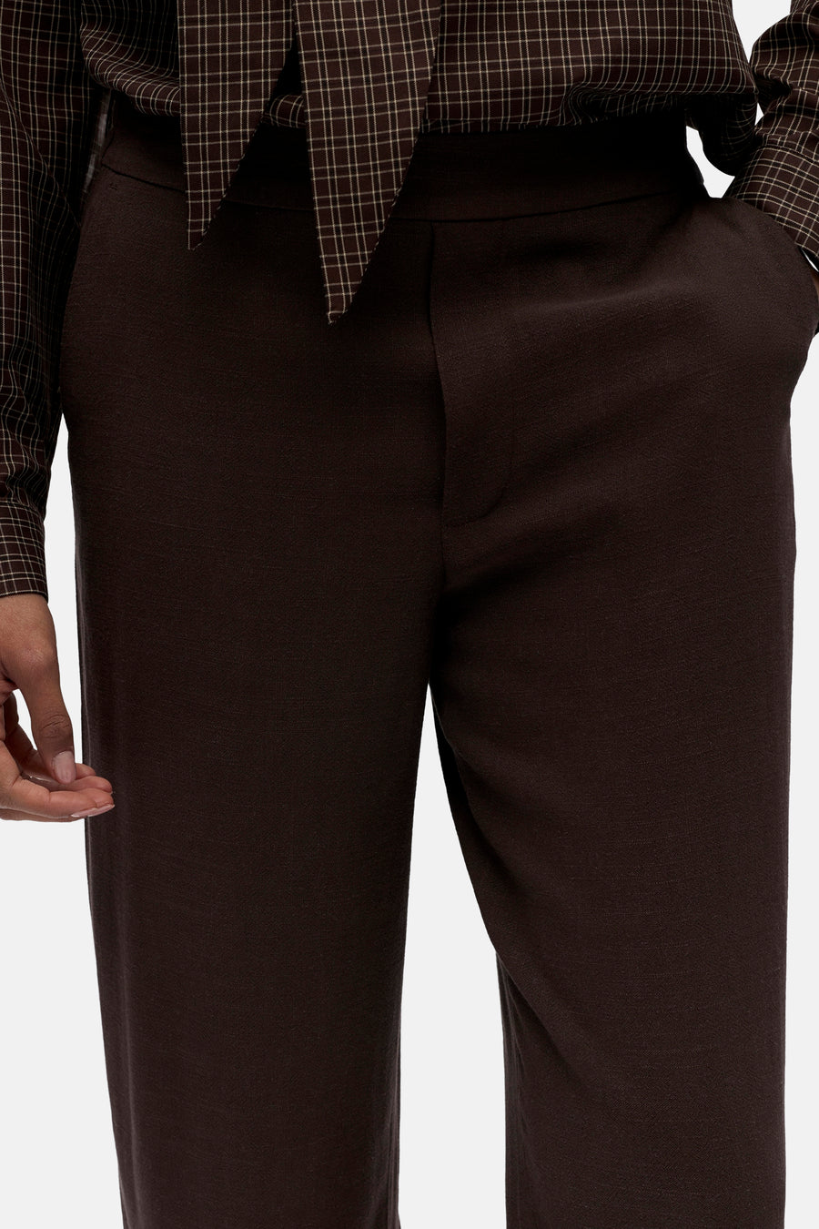 Pantalon marron d'OBJECT, avec un tissu lisse et une ceinture discrète, combiné avec une chemise à carreaux.