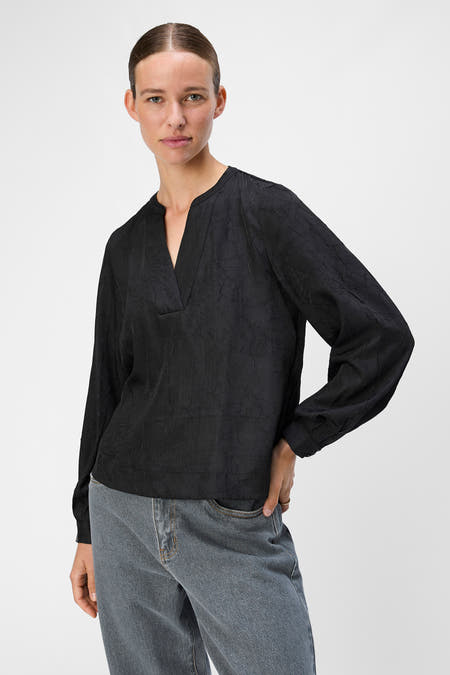Blouse noire à longues manches d'OBJECT, avec une texture froissée et un col V.