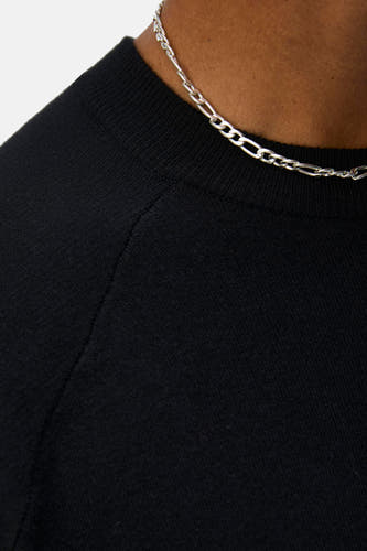 Pull noir de OBJECT, avec un col rond et une chaîne argentée.