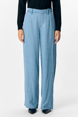 Jean bleu clair d'OBJECT, avec des jambes larges et associé à une chemise noire.