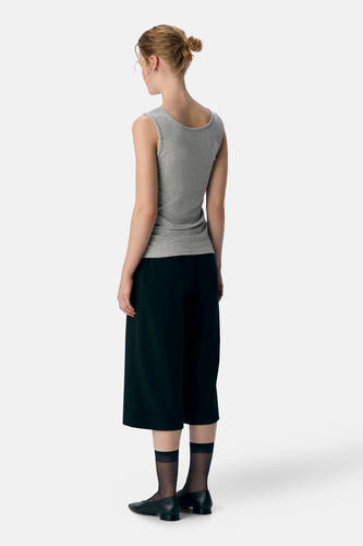 Sous-vêtement gris d'OBJECT, vu de derrière, associé à une culotte noire et des chaussettes noires avec des détails transparents.