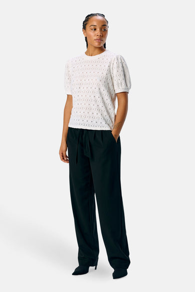 T-shirt blanc à manches courtes d'OBJECT, avec une texture ajourée et porté avec des pantalons noirs décontractés et des baskets.