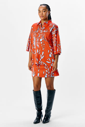 Oranje overhemd met korte mouwen van OBJECT, met een opvallend blauw-wit patroon en gedragen met zwarte kniehoge laarzen.
