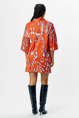 Chemise orange à manches courtes d'OBJECT, avec un motif de feuille et portée avec des bottes noires.