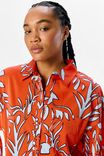 Maillot orange à manches courtes d'OBJECT, avec un motif de feuilles bleu et noir frappant.